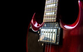 Красная гитара со струнами на черном фоне 