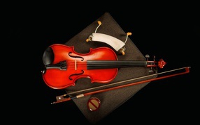 Красная скрипка со смычком на черном фоне