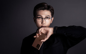 Молодой парень Rm участник группы BTS с телефоном