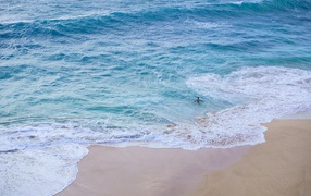 Чистый пляж с белыми морскими волнами на песке