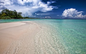 Чистая голубая вода на пляже с желтым песком