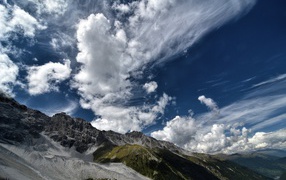 Белые густые облака в голубом небе над горами 