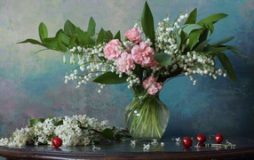 Красивый букет ландышей с розовыми цветами на столе с веткой сирени 