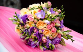 Красивый свадебный букет лежит на розовой ткани