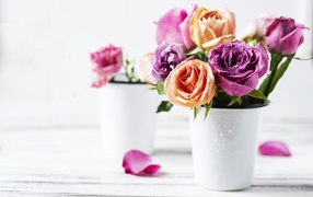 Букет разноцветных роз в белой вазе на столе