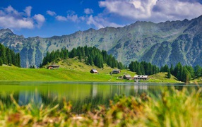 Красивый пейзаж на горы и озеро и зеленые луга