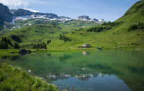 Покрытые зеленью горы у холодного озера 