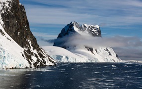 Заснеженные горы у покрытого льдом океана 