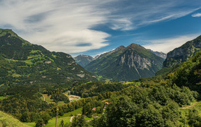 Высокие покрытые зеленью альпы под красивым небом, Швейцария 