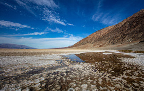 Соленая земля у горы под голубым небом