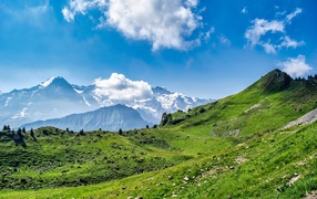 Белые облака над вершинами гор в голубом небе 