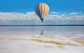 Большой воздушный шар летит на водой