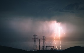 Bright lightning in the sky above the high voltage line
