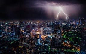 Lightning in the stormy sky over the night metropolis