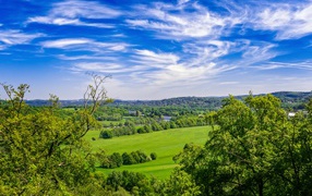 Красивый вид на зеленые холмы под голубым небом летом