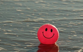 Красный мяч смайлик в воде 