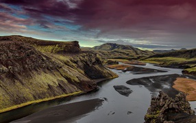 Неглубокая река среди зеленых гор