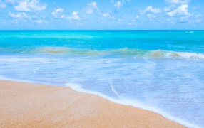 Красивый спокойный голубой океан на желтом песке 
