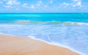 Красивый спокойный голубой океан на желтом песке 