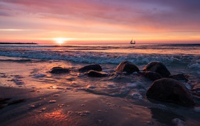 Валуны на берегу моря на мокром песке 