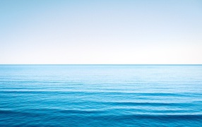 Спокойная голубая морская вода под голубым небом 