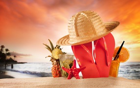 Flip flops, hat and cocktail with pineapple on the beach in summer