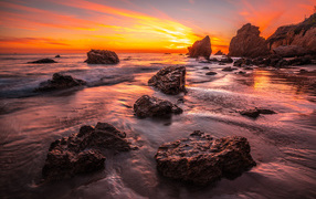 Красивый закат солнца на берегу моря с камнями 