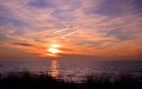 Закат солнца над спокойным озером летом