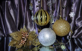 Золотые елочные шарики с украшениями на фоне ткани 