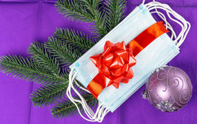 Медицинские маски, бант, еловая ветка и шар на новый год