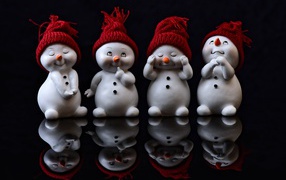 Small figurines of snowmen on a black background