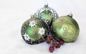 Three green christmas balls for a tree on the snow