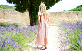 Little girl in a dress on the field with lavender