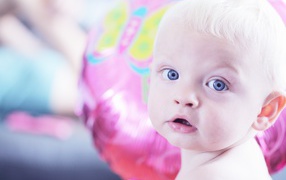 Голубоглазый маленький мальчик на фоне шарика