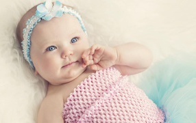 Голубоглазая маленькая девочка с повязкой на голове 