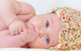 Голубоглазый грудной ребенок в шапке 