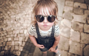 Модная маленькая девочка в черных очках