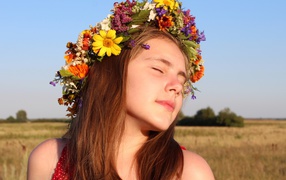 Девочка с закрытыми глазами с венком на голове