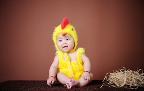 Маленький мальчик азиат в костюме цыпленка