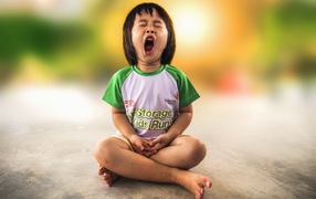 Маленькая девочка азиатка зевает на полу