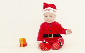 Маленький мальчик в новогоднем костюме на белом фоне