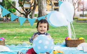 Маленький мальчик с шарами и украшениями на день рождения 