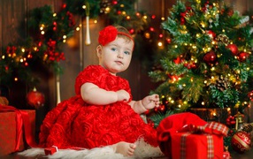 Маленькая девочка в красивом платье у наряженной ели 