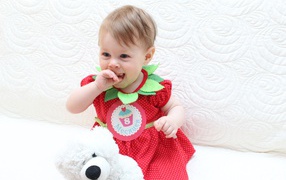 Маленькая девочка в красном платье с игрушкой на белом фоне