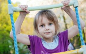 Маленькая девочка на подвесной лестнице 