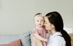 Маленькая девочка с мамой на сером фоне