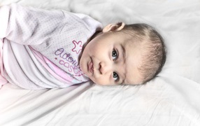 Маленький новорожденный ребенок лежит на кровати 