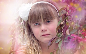 Грустная маленькая девочка у ветки дерева 