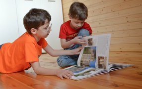 Два маленьких мальчика с книгой  на полу