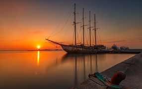 Большой корабль стоит на закате солнца 